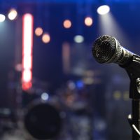 Close up of a microphone on a concert stage with beautiful lighting.